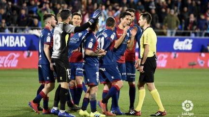 Varios jugaodres del Huesca protestan una decisión a De Burgos Bengoetxea durante el duelo ante el Sevilla.