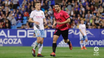 Juan Muñoz celebra ante Nieto su segundo gol en el partido.