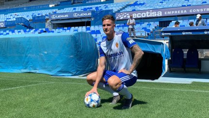 Carlos Vigaray posa con la camiseta del Real Zaragoza sobre el césped de La Romareda.