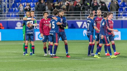 Varios jugadores de la SD Huesca se abrazan tras su último partido oficial, hace 97 días.