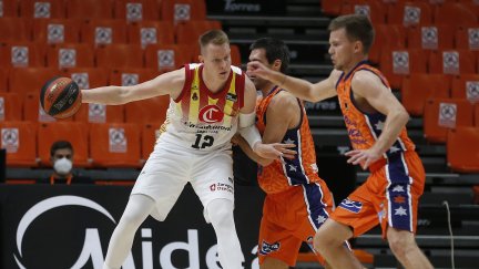 Benzing lucha con dos jugadores en un lance del partido.