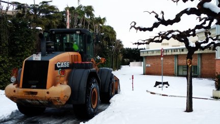Una pala excavadora limpia los accesos a un centro escolar