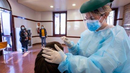 Una sanitaria realiza una PCR a una mujer.