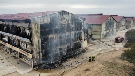 Bomberos sofocando el incendio en la nave.