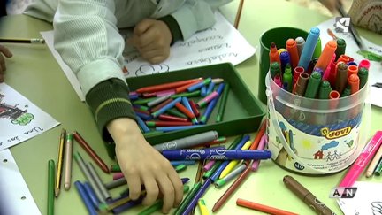 Niño jugando con pinturas en el colegio.