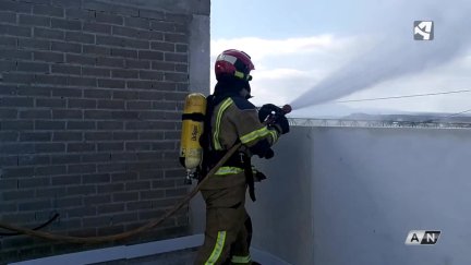 Un bombero echa agua con una manguera durante el simulacro de este sábado en Teruel