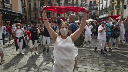 Varias personas alzan un pañuelo rojo en las inmediaciones de la Plaza del Consistorio en el momento en el que de celebrarse los Sanfermines 2020 (EP).