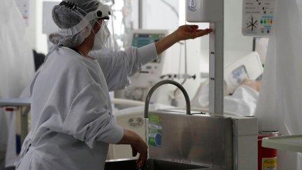 Una sanitaria se desinfecta la manos antes de atender a un paciente.