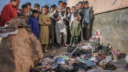 Un grupo de personas observa las pertenencias de las víctimas del atentado en Kabul (Afganistán).