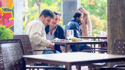 Dos jóvenes sentados en una terraza