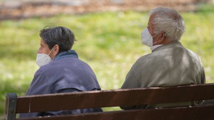 Dos personas mayores con mascarilla en exteriores (EP).