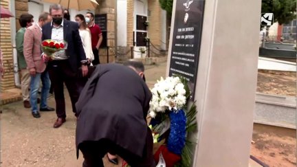 Imagen de un asistente al homenaje depositando un ramo de flores.