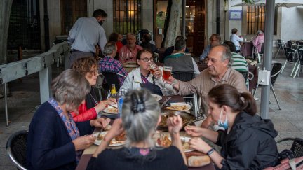 Un grupo de personas cena en una terraza.