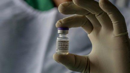 Un sanitario sujeta un vial de la vacuna de Pfizer contra la COVID-19.