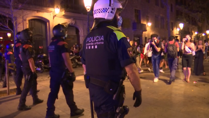 Agentes de los Mossos y Guardia Urbana desalojan la calle en Barcelona a la hora del toque de queda.