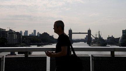 Un hombre sin mascarilla cruza este lunes el Támesis por el Puente de Londres, en la capital británica (EFE).