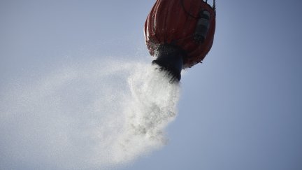 Un helicóptero lanza agua para sofocar un incendio (EP).