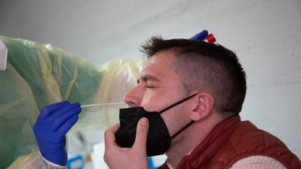 Un sanitario realiza una PCR a un hombre.