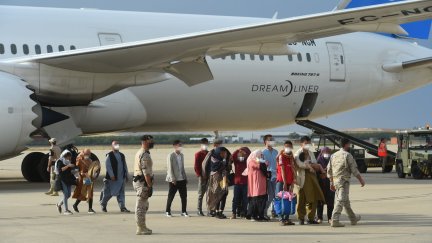 Cooperantes afganos y sus familias a su llegada a la base de Torrejón. EFE)