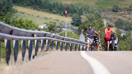 Dos peregrinos transitan por el arcén de una carretera. (EP)