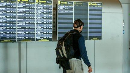 Un hombre mira las pantallas de información sobre vuelos en un aeropuerto.