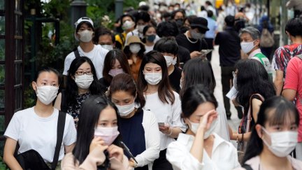 Jóvenes japoneses en las inmediaciones de un centro de vacunación en Tokio (Japón).
