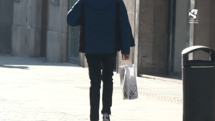 Usuario que camina con una bolsa de compra en Huesca.