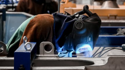 Un empleado trabaja sobre una pieza metálica en una factoría (EP)