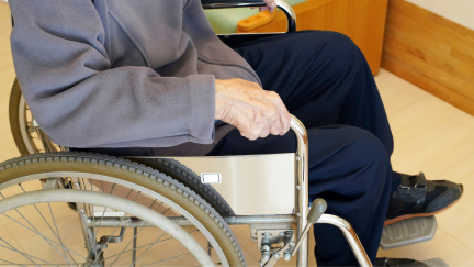 Persona dependiente en silla de ruedas (Canva).