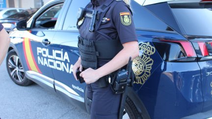 Imagen de un agente de policía junto al coche.