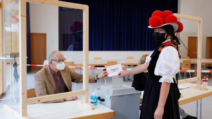 Una mujer con un atuendo típico vota en las elecciones alemanas de este domingo.