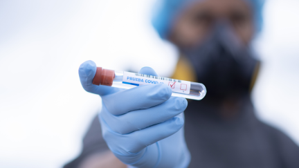 Un sanitario con una muestra de COVID-19.