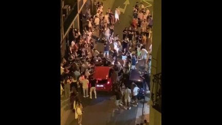 Un grupo de jóvenes increpa a un vehículo que trata de atravesar una céntrica calle de Zaragoza.