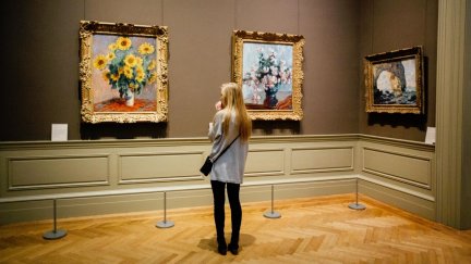 Una chica joven visita un museo (Canva).