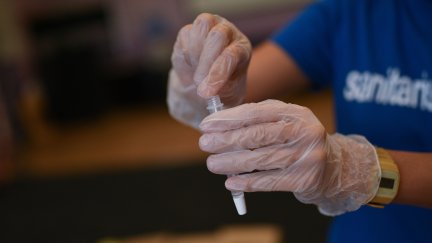 Un sanitario sostiene una prueba PCR.