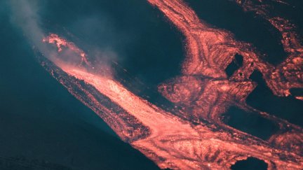 Imagen tomada ayer domingo, 24 de octubre, de la nueva boca de la parte inferior del cono secundario del volcán, de la que sale abundante lava (EFE).