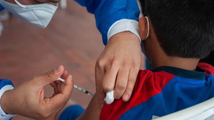 Una sanitaria, vacunando a un niño. (Foto: EP)