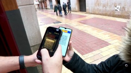 Escaneo de un pasaporte COVID a la entrada de un bar.