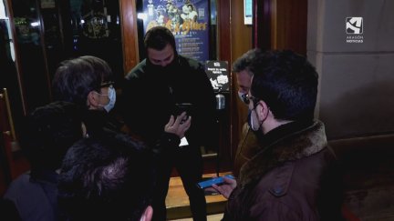 Un portero de discoteca comprueba los pasaportes Covid.