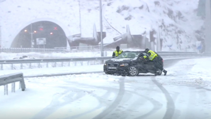 Agentes de la Guardia Civil ayudan a un conductor atascado en la nieve.
