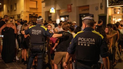 Agentes de la Guardia Urbana de Barcelona se dirigen a la multitud para controlar aglomeraciones en las fiestas del barrio de Gràcia. / Foto: EP