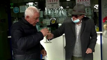 Dos vecinos de Calatayud brindan en una administración tras ganar un quinto premio.