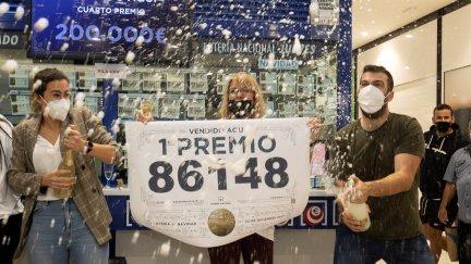 Varias personas, celebrando con champán el primer premio en Atocha. / Foto: EFE