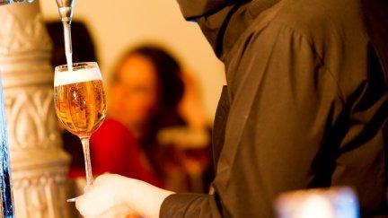 Un camarero sirve una caña en un bar.