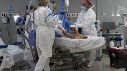 Varios sanitarios atienden a un paciente en la UCI.