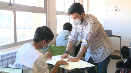 Un profesor ayuda a un alumno.
