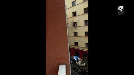 Una persona salta por la ventana para huir de las llamas. / EFE