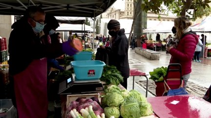 Varios clientes en un mercado ecológico.