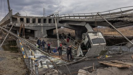 Residentes de Irpin, cerca de Kiev, intentan cruzar un puente destruido durante los ataques. (FE/EPA/ROMAN PILIPEY)