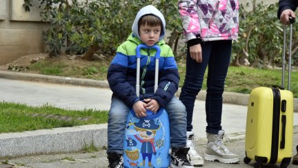 Un niño refugiado junto a su maleta. / Foto: EP